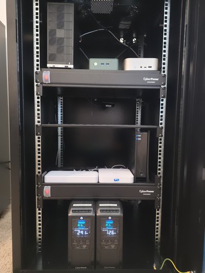 Closer view inside the server rack, showing the computers, rack shelves, and two UPS displays.